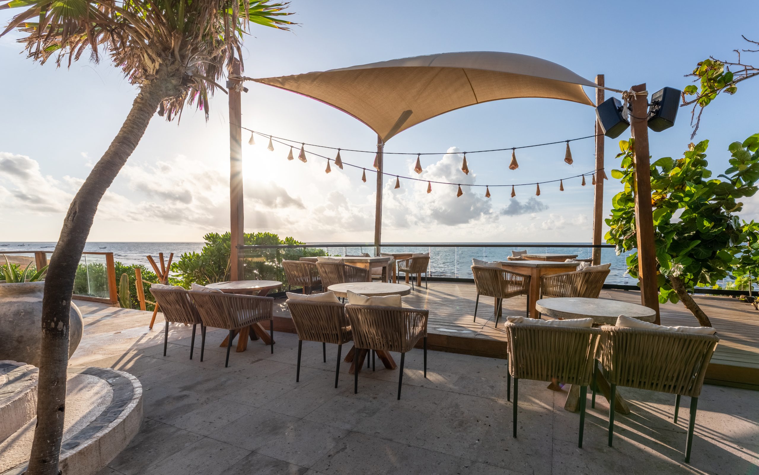 Shaded dining terrace at Mezzanine overlooking the Caribbean Sea in Tulum